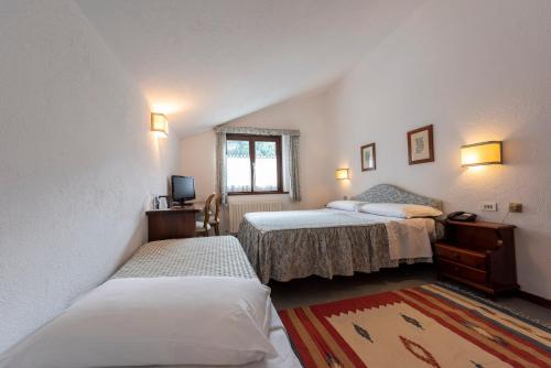 库马约尔特里欧蕾酒店的一间卧室设有两张床和窗户。