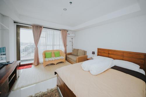 万隆Apartemen Tera Residence的卧室配有床、椅子和窗户。