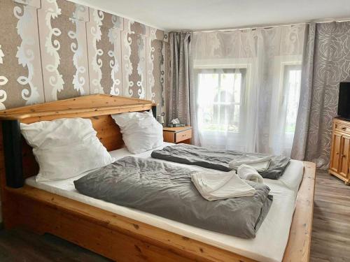 莱茵河畔林茨The Burgklause Boutique Hotel的一间卧室配有一张大床和木制床头板