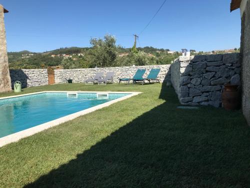 拜昂Casa da Ponte的一个带游泳池和石墙的庭院