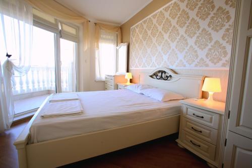 拉夫达Villa Livia Boutique Apartments的一间卧室配有一张带两盏灯的床和一扇窗户。