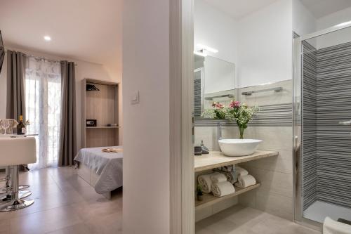 阿尔盖罗Atteros的白色的浴室设有水槽和淋浴。