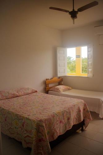 科曼达图巴岛Pousada Pau Brasil的一间卧室设有两张床和窗户。