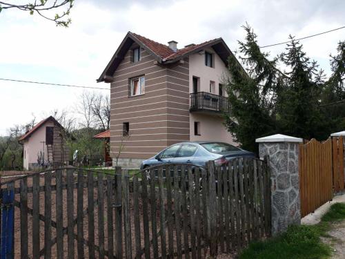 兹拉蒂博尔Zlatiborska seoska idila的前面有栅栏和汽车的房子