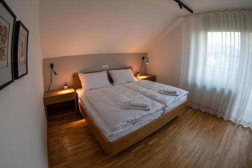 森克Hiša na Vrtu的一间卧室配有一张带2个床头柜的大床