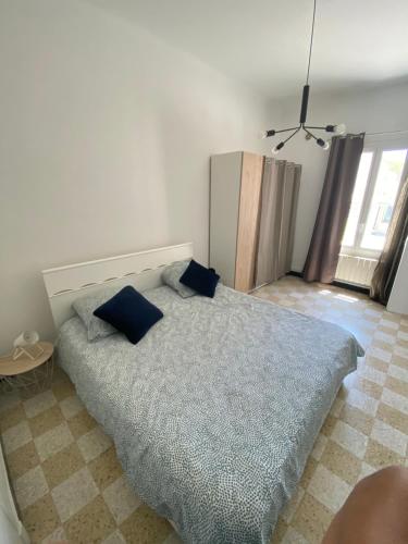 滨海卡涅Maisonnette Cagnes的一间卧室配有一张带蓝色枕头的床。