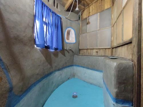 圣胡安特奥蒂瓦坎Temazcal Casa de Barro的一间客房内的蓝色浴缸浴室