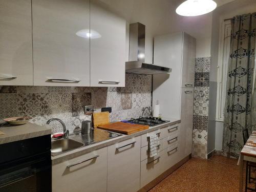 热那亚Appartamento Tolemaide的厨房配有白色橱柜和水槽