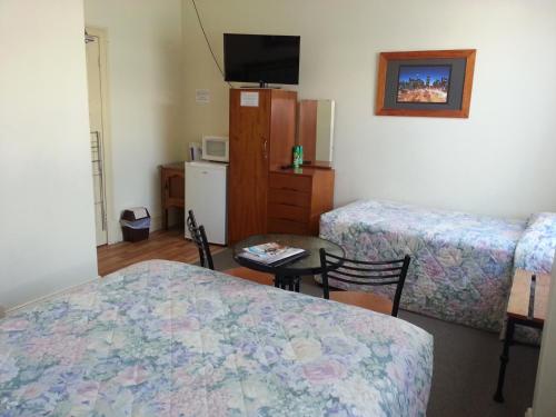 沃拉鲁松本汽车旅馆的客房设有两张床、一张桌子和一台电视机。