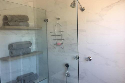 库马The Hermitage的玻璃门淋浴和一些毛巾