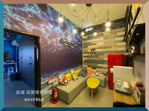 Huxi澎湖 玩聚背包民宿的一间配有沙发和空间壁画的房间