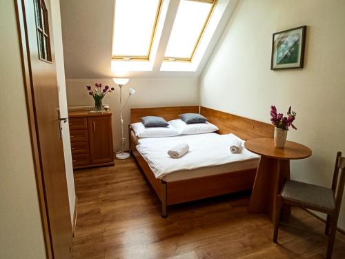 卡尔帕奇Apartamenty i Pokoje u Doroty的一间卧室设有两张床、一张桌子和一个窗口
