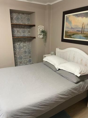 巴里吉斯Les Sorbiers Barèges的卧室配有一张白色床,墙上挂着一幅画
