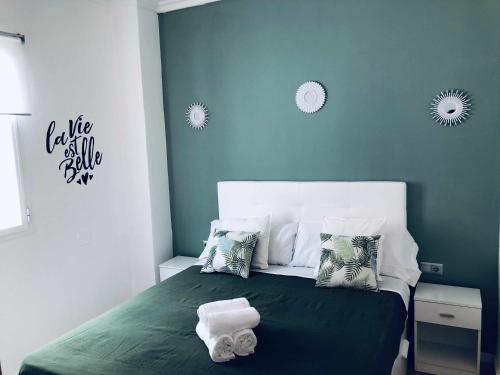 马拉加Sunlight Málaga Centro的一间卧室配有绿床和毛巾