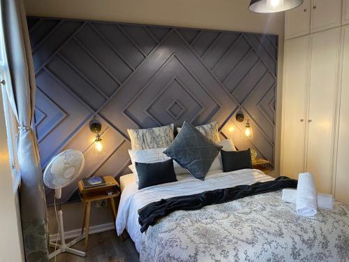 开普敦Just Off Long - Inner City Gem的一间卧室配有一张大床和木制床头板