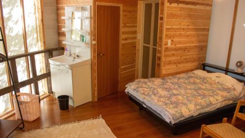 雾岛市Glamping Himeshara - Vacation STAY 43046v的木制客房内的一间卧室,配有一张床