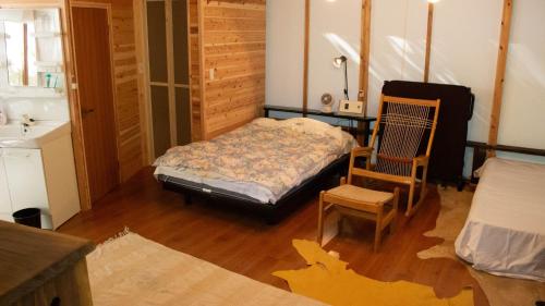 雾岛市Glamping Himeshara - Vacation STAY 43046v的一间卧室配有一张床和一把椅子