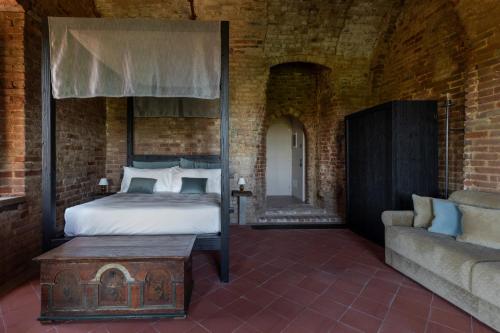 ArignanoRocca di Arignano的一间卧室配有天蓬床和沙发