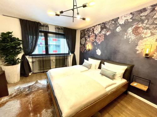 弗莱堡Boutique Apartment am Bahnhof的一间卧室配有一张带花卉墙壁的床