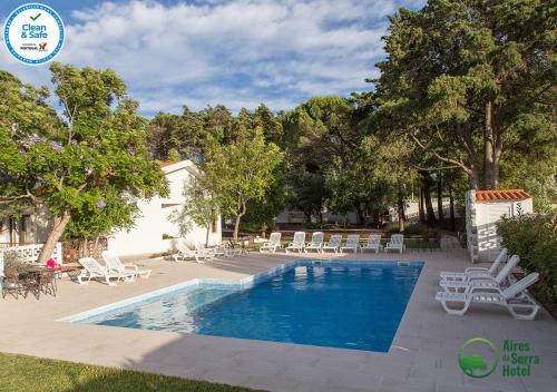 托雷斯诺瓦斯Aires da Serra Hotel的一个带躺椅的游泳池和一个游泳池