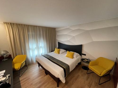 布雷斯特罗吉思酒店的酒店客房,配有床和两张黄色椅子