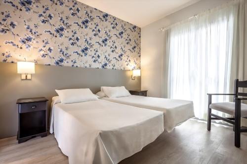 洛斯克里斯蒂亚诺斯Apartamentos HG Cristian Sur的一间卧室配有床和蓝白壁纸