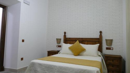 San Benito de la ContiendaLA CASONA DE MANUELA的一间卧室配有带白色和黄色枕头的床