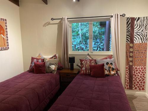 库兰达库兰达恩戈罗恩戈罗山林小屋的一间卧室设有两张床和窗户。