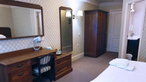 斯托克波特布雷德贝里豪尔酒店的一间带水槽和镜子的浴室以及一张床