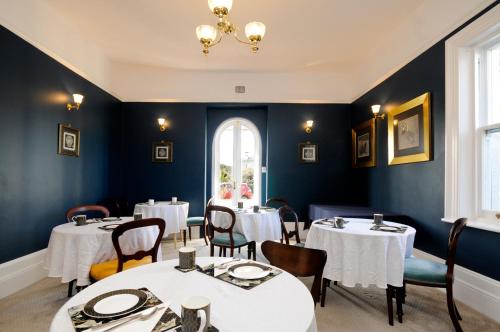 朗塞斯顿文达拉旺海住宿加早餐旅馆的餐厅设有白色的桌椅和窗户。