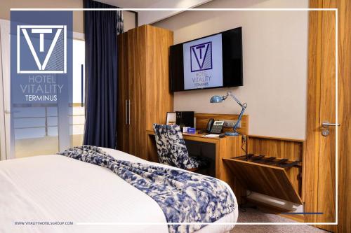盖尼特拉Hotel Vitality Terminus的配有一张床和一张书桌的酒店客房