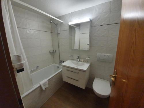贝尔瓦尔德大使公寓式酒店的浴室配有盥洗盆、卫生间和浴缸。
