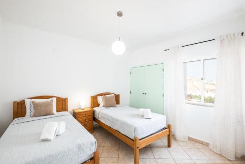 阿尔布费拉Albufeira - 3 bedrooms - free wifi的一间卧室设有两张床和窗户。