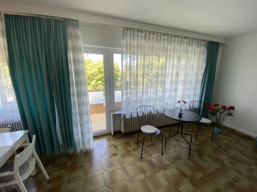 巴特瑙海姆Ferienwohnung Südpark Apartment - Bad Nauheim的客厅配有桌椅和窗户。
