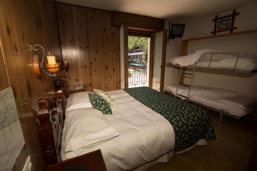 利莫内皮埃蒙特艾德尔韦斯酒店的一间卧室配有一张床和一张双层床,设有窗户