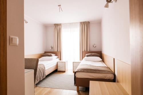 梅斯瓦科维采查塔扎维希亚酒店的酒店客房设有两张床和窗户。
