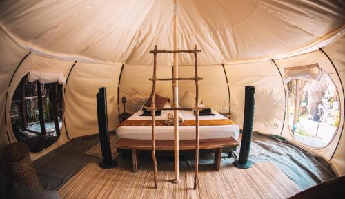 图卢姆Uman Glamping & Cenote Tulum的帐篷内的卧室,配有一张床