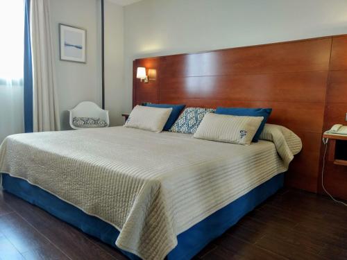 埃斯基维亚斯伊达尔戈酒店的一间卧室配有一张大床和木制床头板
