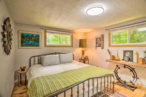 马吉谷Vintage Creekside Cottage with Hot Tub and Grill!的一间卧室设有一张床和两个窗户。