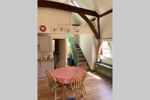 DepdenGorgeous comfortable barn with huge private orchard in quiet Suffolk location的一间带桌椅和楼梯的用餐室