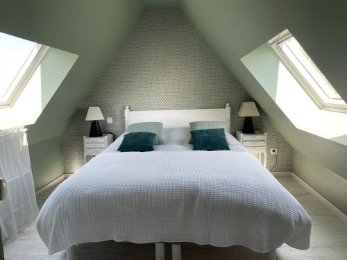 Tardinghenles gites du grand saule的一间卧室配有白色床和蓝色枕头