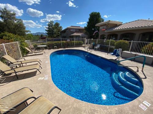 卡顿伍德Pines Inn & Suites的一个带椅子的游泳池和一个游泳池