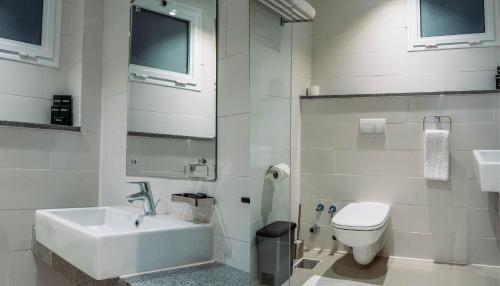 塞得港Palma Hotel的白色的浴室设有水槽和卫生间。