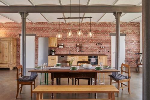 埃瑟尔re~barn - Modern Country Stay的一间设有桌子和砖墙的用餐室