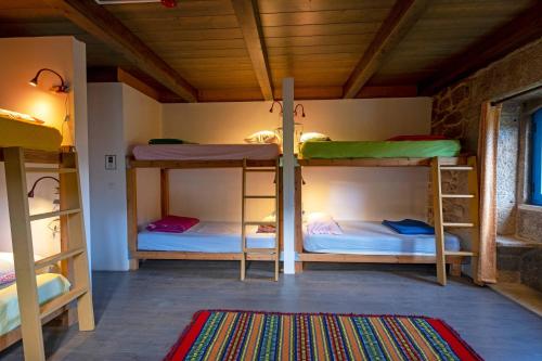 CerdalQuinta Estrada Romana - Albergue de Peregrinos的带三张双层床和地毯的房间