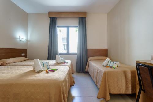 福恩吉罗拉Hostal Costabella powered by Faro Homes的酒店客房设有两张床和窗户。