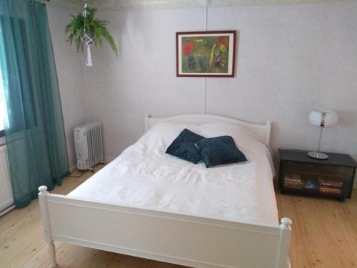 TohkalaOliveira Guesthouse的卧室内的一张带两个枕头的白色床