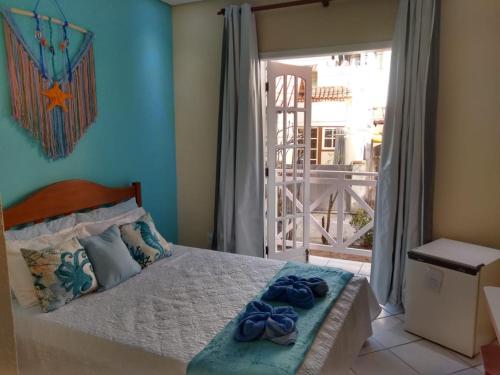 阿布拉奥Pousada Arrastão da Ilha的一间卧室配有一张带2条蓝色毛巾的床