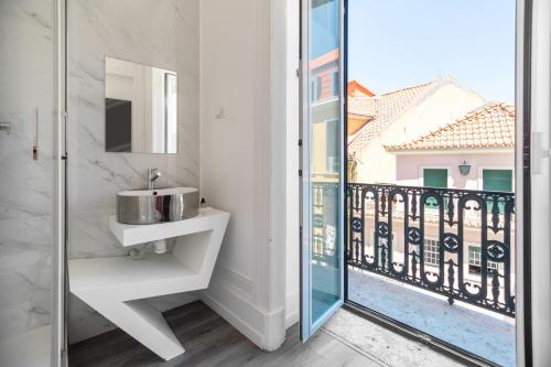 里斯本The Hygge Lisbon Suites - Estrela的一间带水槽的浴室和一个阳台