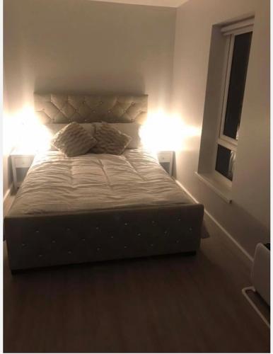 Walton on the HillThe Bungaloaf的一间卧室配有一张带两个灯的床